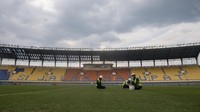 Pekerja merawat rumput lapangan sepak bola saat renovasi Stadion Si Jalak Harupat di Soreang, Kabupaten Bandung, Jawa Barat, Sabtu (11/3/2023). Renovasi Stadion Si Jalak Harupat tersebut ditujukan untuk perhelatan Piala Dunia U-20 pada Mei hingga Juni 2023 mendatang. ANTARA FOTO/M Agung Rajasa  