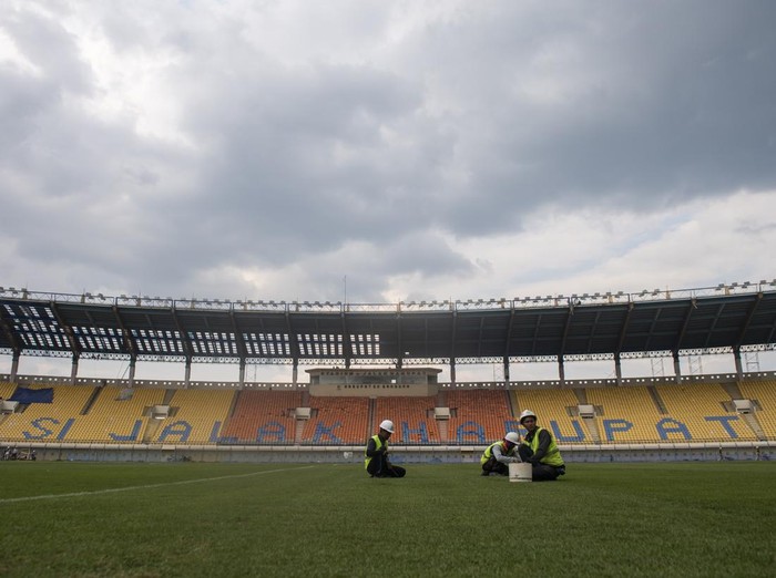Pekerja merawat rumput lapangan sepak bola saat renovasi Stadion Si Jalak Harupat di Soreang, Kabupaten Bandung, Jawa Barat, Sabtu (11/3/2023). Renovasi Stadion Si Jalak Harupat tersebut ditujukan untuk perhelatan Piala Dunia U-20 pada Mei hingga Juni 2023 mendatang. ANTARA FOTO/M Agung Rajasa/nym.