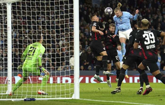 Manchester Citys Erling Haaland heads the ball which led to scoring his sides fifth goal of the game during the Champions League round of 16 second leg soccer match between Manchester City and RB Leipzig at the Etihad stadium in Manchester, England, Tuesday, March 14, 2023. (Nick Potts/PA via AP)