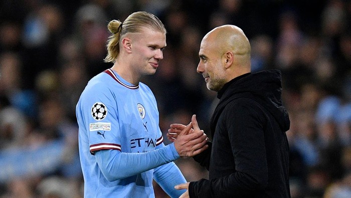 Manchester Citys Norwegian striker Erling Haaland (L) shakes hands with Manchester Citys Spanish manager Pep Guardiola as he leaves the pitch after being substituted off during the UEFA Champions League round of 16 second-leg football match between Manchester City and RB Leipzig at the Etihad Stadium in Manchester, north west England, on March 14, 2023. (Photo by Oli SCARFF / AFP) (Photo by OLI SCARFF/AFP via Getty Images)