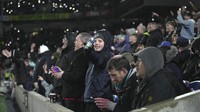 Kerlipan cahaya masih terlihat dari telepon seluler suporter di stadion. Apalagi banyak pula fans yang sengaja mengangkat tinggi-tinggi lampu senter di ponselnya. Foto: AP/Kin Cheung