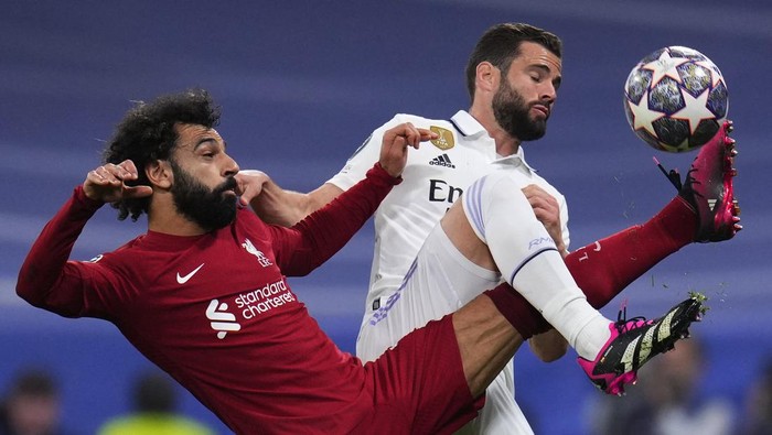 Liverpools Mohamed Salah, left, challenges for the ball with Real Madrids Nacho during the Champions League, round of 16 second leg soccer match between Real Madrid and Liverpool at the Santiago Bernabeu stadium in Wednesday, March 15, 2023. (AP Photo/Manu Fernandez)