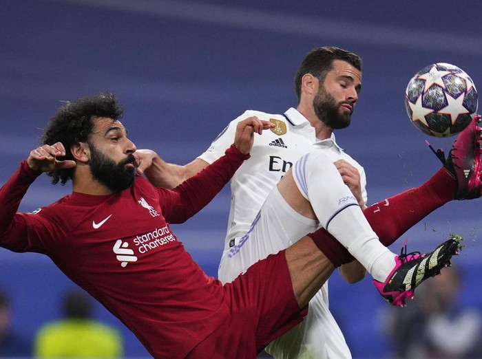 Liverpool's Mohamed Salah, left, challenges for the ball with Real Madrid's Nacho during the Champions League, round of 16 second leg soccer match between Real Madrid and Liverpool at the Santiago Bernabeu stadium in Wednesday, March 15, 2023. (AP Photo/Manu Fernandez)
