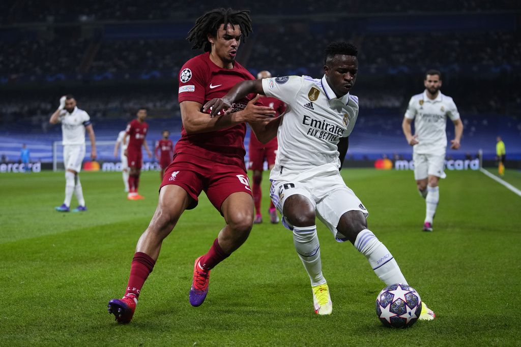 Real Madrid's Vinicius Junior, right and Liverpool's Trent Alexander-Arnold challenge for the ball during the Champions League, round of 16 second leg soccer match between Real Madrid and Liverpool at the Santiago Bernabeu stadium in Wednesday, March 15, 2023. (AP Photo/Manu Fernandez)