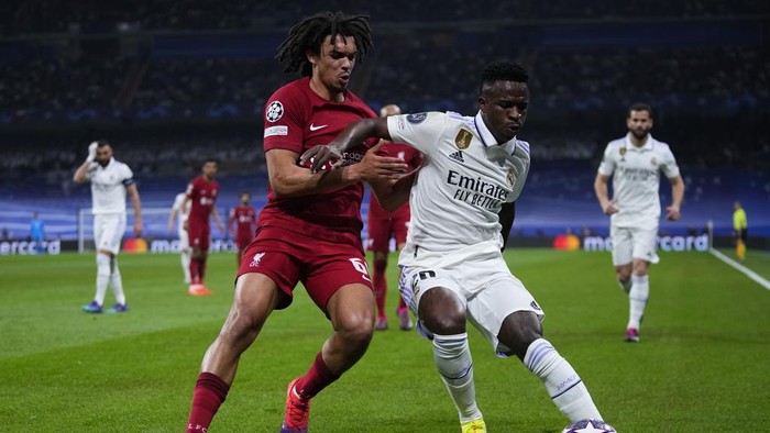 Real Madrids Vinicius Junior, right and Liverpools Trent Alexander-Arnold challenge for the ball during the Champions League, round of 16 second leg soccer match between Real Madrid and Liverpool at the Santiago Bernabeu stadium in Wednesday, March 15, 2023. (AP Photo/Manu Fernandez)