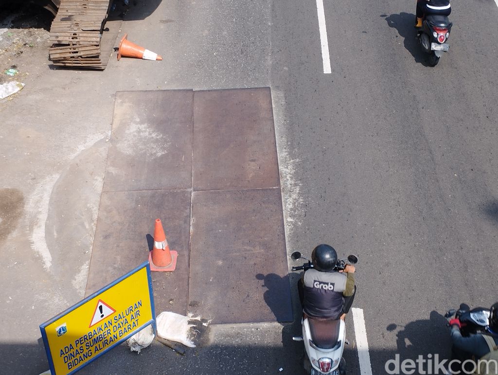 Lubang besar di Jalan Daan Mogot sudah ditambal dan ditutup pelat besi. (Brigitta Belia Permata Sari/detikcom)