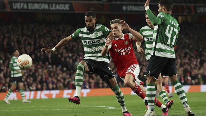 Sporting's Jeremiah St. Juste, left, duels for the ball with Arsenal's Leandro Trossard, center, during the Europa League round of 16, second leg, soccer match between Arsenal and Sporting CP at the Emirates stadium in London, Thursday, March 16, 2023. (AP Photo/Ian Walton)
