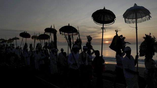 Siluet Umat Hindu saat membawa benda sakral dalam upacara Melasti di Pantai Padang Galak, Denpasar, Bali, Sabtu (18/3/2023). Upacara yang bertujuan menyucikan diri dan alam tersebut merupakan rangkaian dari Hari Raya Nyepi Tahun Baru Saka 1945 yang jatuh pada Rabu (22/3). ANTARA FOTO/Nyoman Hendra Wibowo/nym.