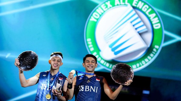 Fajar Alfian, Muhammad Rian Ardianto BIRMINGHAM, ENGLAND - MARCH 19: Fajar Alfian (R) and Muhammad Rian Ardianto of Indonesia pose with their trophies on the podium after the Mens Double Final match against Mohammad Ahsan and Hendra Setiawan of Indonesiaon on day six of the Yonex All England Badminton Championships at Utilita Arena Birmingham on March 19, 2023 in Birmingham, England. (Photo by Shi Tang/Getty Images)