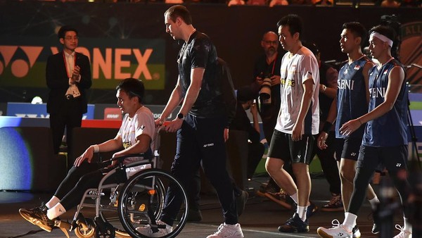 Mohammad Ahsan attends the podium in a wheelchair after an injury during the mens double final match against Indonesias Indonesias Fajar Alfian and Muhammad Rian Ardinanto in the All England Open Badminton Championships at the Utilita Arena in Birmingham, England, Sunday, March 19, 2023. (AP Photo/Rui Vieira)