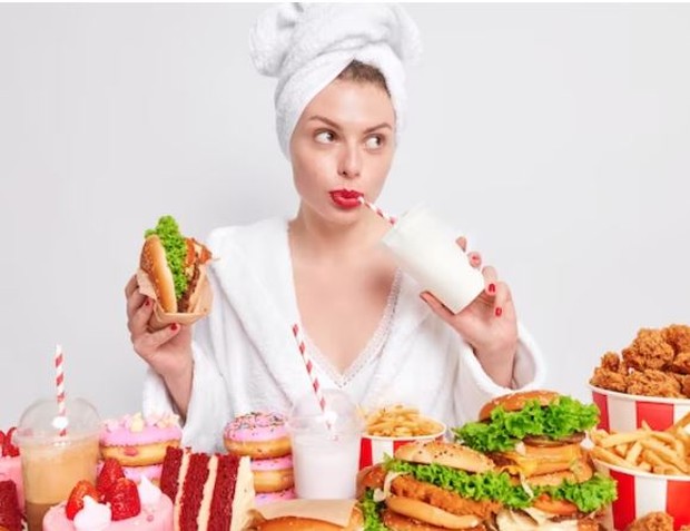 Perempuan sedang makan banyak fast food