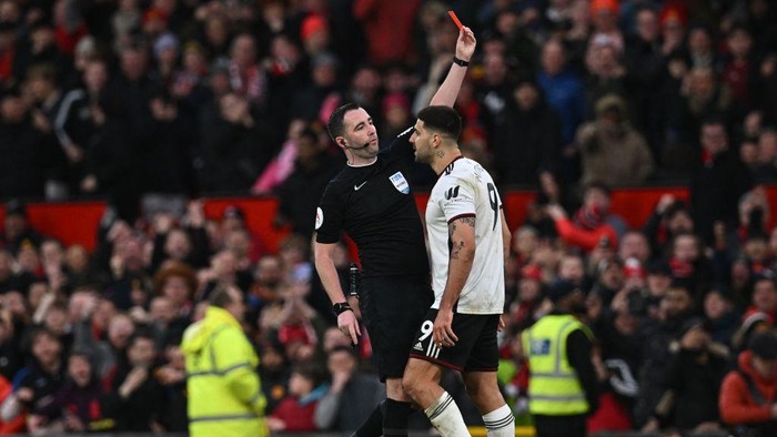 Fulhams Serbian striker Aleksandar Mitrovic (R) is shown a red card by English referee Chris Kavanagh (L) during the English FA Cup quarter-final football match between Manchester United and Fulham at Old Trafford in Manchester, north-west England, on March 19, 2023. (Photo by Paul ELLIS / AFP) / RESTRICTED TO EDITORIAL USE. No use with unauthorized audio, video, data, fixture lists, club/league logos or live services. Online in-match use limited to 120 images. An additional 40 images may be used in extra time. No video emulation. Social media in-match use limited to 120 images. An additional 40 images may be used in extra time. No use in betting publications, games or single club/league/player publications. /  (Photo by PAUL ELLIS/AFP via Getty Images)