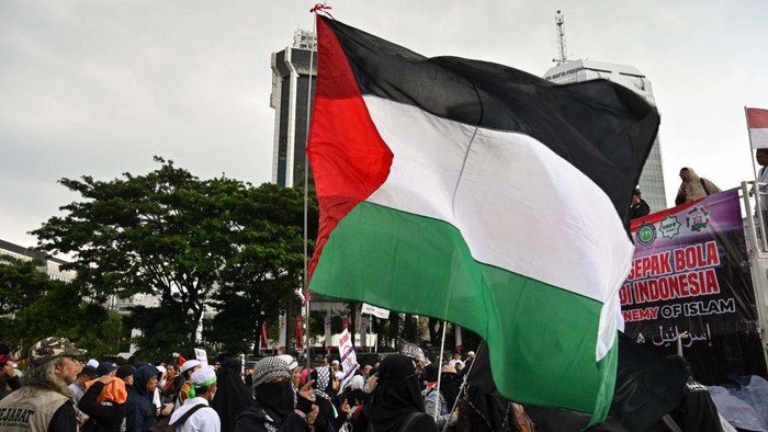 An Indonesian woman holds the flag of Palestine during a rally in Jakarta on March 20, 2023 to demand the Indonesian government to reject the participation of Israels team in the upcoming 2023 FIFA U-20 World Cup, which is to be hosted by Indonesia between May 20 and June 11. (Photo by ADEK BERRY / AFP) (Photo by ADEK BERRY/AFP via Getty Images)