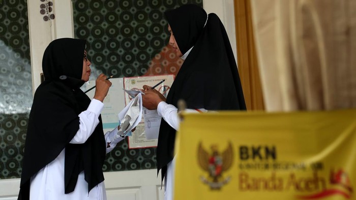 Kemenag Mulai Seleksi 74 Ribu Calon PPPK Peserta calon Pegawai Pemerintah dengan Perjanjian Kerja (PPPK) Kementerian Agama berbincang usai mengikuti ujian kompetensi dengan sistem Computer Assisted Test (CAT) di gedung Amel Convention, Banda Aceh, Aceh, Kamis (23/3/2023). Sebanyak 74.424 peserta calon PPPK Kementerian Agama di seluruh Indonesia akan mengikuti seleksi sejak 17 Maret hingga 9 April 2023 untuk memperebutkan 49.549 formasi yang tersedia. ANTARA FOTO / Irwansyah Putra/foc.