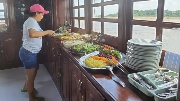 Juru masak merangkap petugas kebersihan dan pelayan bar, menyiapkan makanan sehari 3 kali untuk penumpang kapal Dorinha.