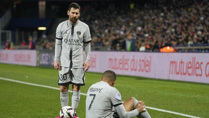 PSGs Lionel Messi stands next to injured PSGs Kylian Mbappe during the French League One soccer match between Montpellier and Paris Saint-Germain at the State La Mosson stadium in Montpellier, France, Wednesday, Feb. 1, 2023. (AP Photo/Thibault Camus)