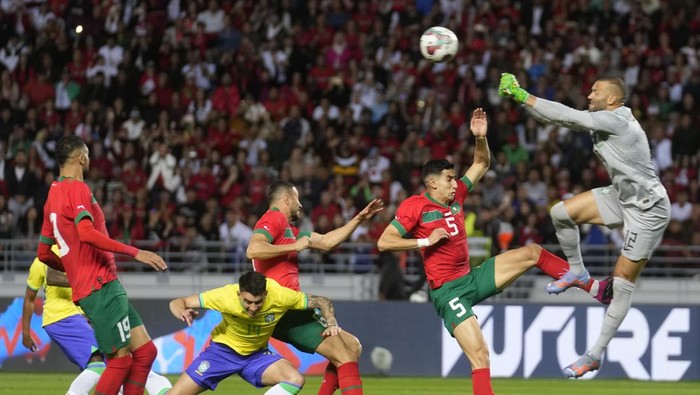 Brazils goalkeeper Weverton clears the ball away challenged by Moroccos Nayef Aguerd, second from right during the friendly soccer match between Morocco and Brazil at the Ibn-Batouta stadium, in Tangier, Morocco, Saturday, March 25, 2023. (AP Photo/Mosaab Elshamy)
