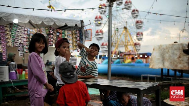 Sejumlah anak naik komedi putar di lapangan Kopelindo, Rangkapan Jaya, Depok, Jawa Barat. Komedi putar ini menjadi salah satu pilihan warga untuk menghabiskan waktu berbuka puasa ramadan 1444 H. Senin (27/3/2023). CNN Indonesia / Andry Novelino