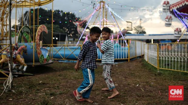 Sejumlah anak naik komedi putar di lapangan Kopelindo, Rangkapan Jaya, Depok, Jawa Barat. Komedi putar ini menjadi salah satu pilihan warga untuk menghabiskan waktu berbuka puasa ramadan 1444 H. Senin (27/3/2023). CNN Indonesia / Andry Novelino