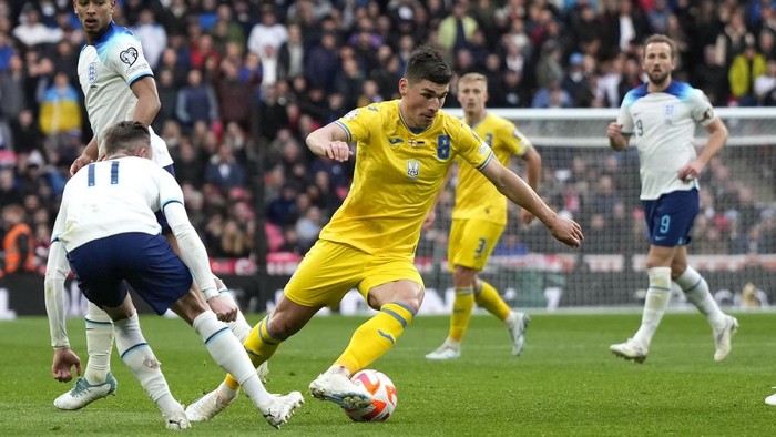 Inggris Tumbangkan Ukraina di Kualifikasi Euro 2024 Ukraine's Ruslan Malinovskyi, centre, in action against Englands' James Maddison, left, during the Euro 2024 group C qualifying soccer match between England and Ukraine at Wembley Stadium in London, Sunday, March 26, 2023. (AP Photo/Alastair Grant)