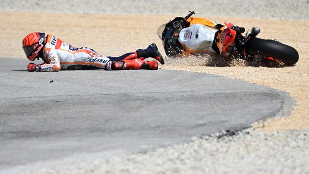 Honda Spanish rider Marc Marquez falls after crashing with Aprilia Portuguese rider Miguel Oliveira (out of frame) during the MotoGP race of the Portuguese Grand Prix at the Algarve International Circuit in Portimao, on March 26, 2023. (Photo by PATRICIA DE MELO MOREIRA / AFP)