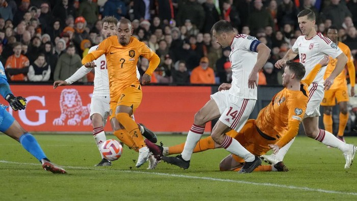 A sliding Netherlands' Wout Weghorst, right, tries to score as Netherlands' Donyell Malen, left with number 7, watches during the Euro 2024 group B qualifying soccer match between the Netherlands and Gibraltar at De Kuip stadium in Rotterdam, Netherlands, Monday, March 27, 2023. (AP Photo/Peter Dejong)