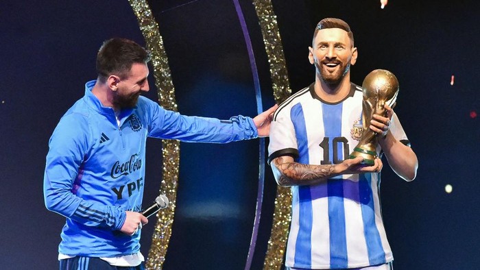 TOPSHOT - Argentinas forward Lionel Messi looks at a statue of himself during a tribute by Conmebol to the members of the Argentine national team for winning the Qatar 2022 World Cup, before the draw of the group phases of the Libertadores and Sudamericana football tournaments, at Conmebols headquarters in Luque, Paraguay, on March 27, 2023. (Photo by NORBERTO DUARTE / AFP) (Photo by NORBERTO DUARTE/AFP via Getty Images)