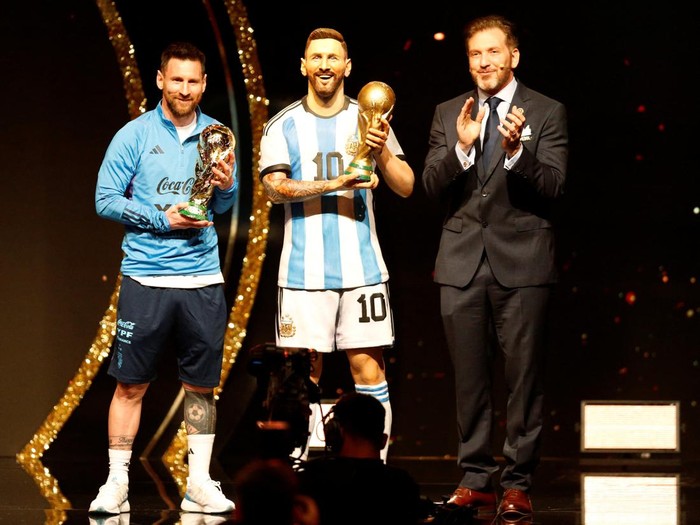 Soccer Football - Copa Libertadores - Draw - Conmebol headquarters, Luque, Paraguay - March 27, 2023 Conmebol president Alejandro Dominguez and Argentina's Lionel Messi posing with a statue of himself holding the World Cup. REUTERS/Cesar Olmedo