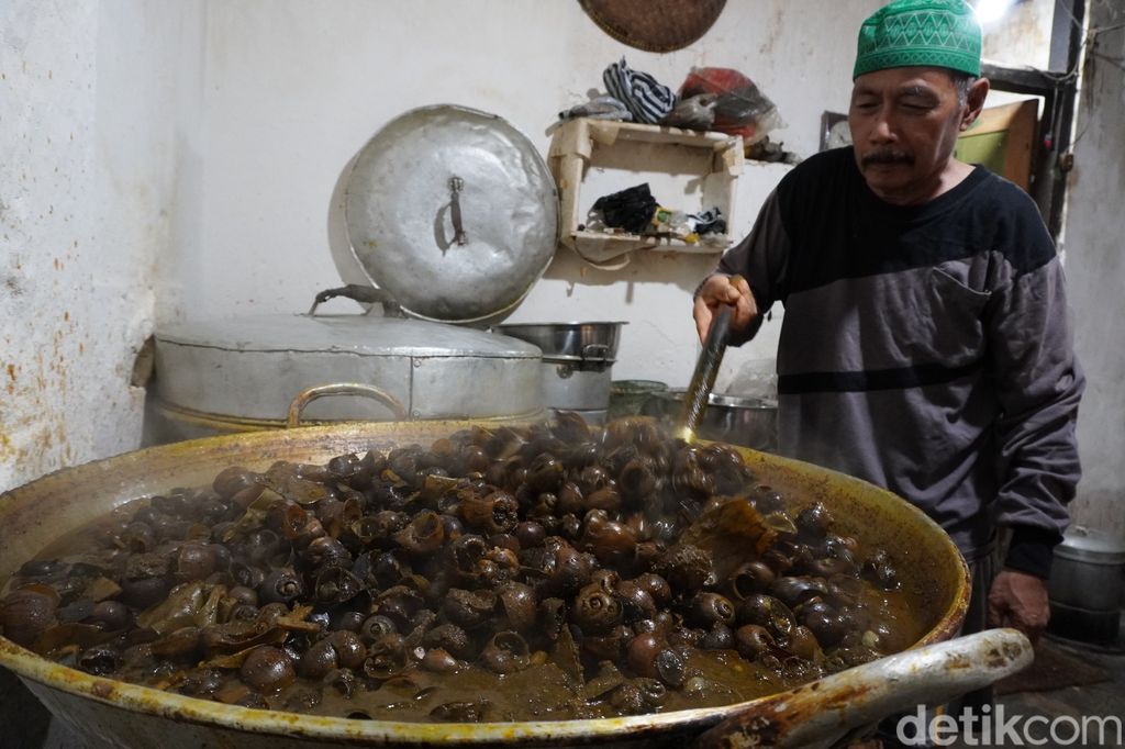 Chamlani (63) mengolah masakan keong khas bulan Ramadan di kediamannya jalan Kauman Lama, Purwokerto Timur, Kabupaten Banyumas, Rabu (29/3/2023).