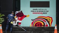 Petugas membersihkan lantai di dekat papan promosi Piala Dunia U-20 Indonesia 2023 di kawasan GBK Arena, Senayan, Jakarta. Namun, papan hitung mundur itu telah berhenti.