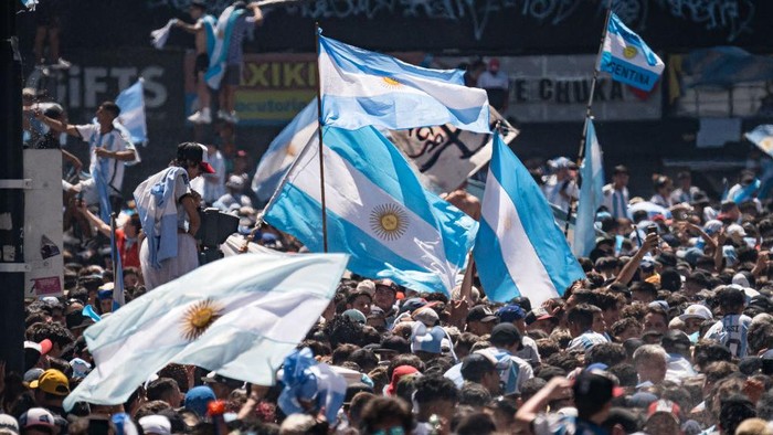 BUENOS AIRES - ARGENTINA, DECEMBER 20: Argentinians celebrating their nationâs third World Cup victory, in the capital Buenos Aires, Argentina on December 20, 2022. On Sunday, Messi-led Argentina beat France 4-2 on penalties in Qatar to bag the nations third FIFA World Cup title. The Argentine national team was expected to tour the streets of the city by bus, but the number of people in the streets exceeded expectations and made it impossible for the team to arrive, which had to be evacuated by helicopter without completing the tour. (Photo by Diego Radames/Anadolu Agency via Getty Images)