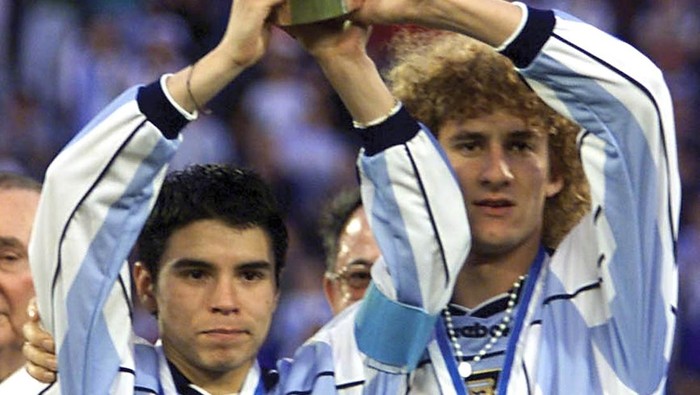 Javier Saviola (L) and Fabricio Coloccini of Argentina raise the World Youth Soccer Championship trophy 08 July 2001 after winning the final game of the championship against Ghana at the Jose Amalfitani stadium in Buenos Aires, Argentina. Argentina won the game 3-0.   AFP PHOTO/Antonio SCORZA / AFP PHOTO / -        (Photo credit should read -/AFP via Getty Images)