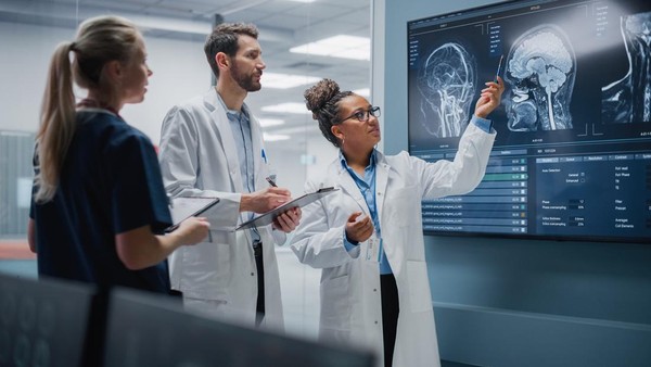 Medical Science Hospital Lab Meeting: Diverse Team of Neurologists, Neuroscientists, Neurosurgeon Consult TV Screen Showing MRI Scan with Brain Images, Talk About Treatment Method, New Drugs Cure