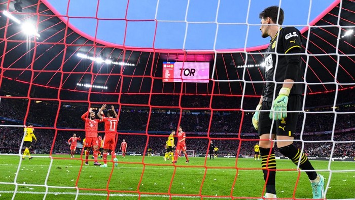 01 April 2023, Bavaria, Munich: Soccer: Bundesliga, Bayern Munich - Borussia Dortmund, Matchday 26 at Allianz Arena. Eric Maxim Choupo-Moting (l) and Kingsley Coman of Munich celebrate the goal for 4:0. Goalkeeper Gregor Kobel (r) of Dortmund could not prevent the goal. Photo: Sven Hoppe/dpa - IMPORTANT NOTE: In accordance with the requirements of the DFL Deutsche Fußball Liga and the DFB Deutscher Fußball-Bund, it is prohibited to use or have used photographs taken in the stadium and/or of the match in the form of sequence pictures and/or video-like photo series. (Photo by Sven Hoppe/picture alliance via Getty Images)