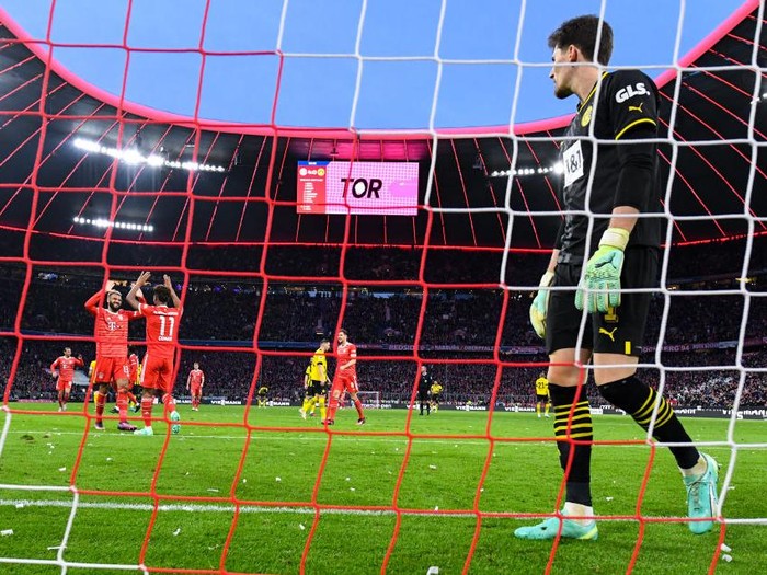 01 April 2023, Bavaria, Munich: Soccer: Bundesliga, Bayern Munich - Borussia Dortmund, Matchday 26 at Allianz Arena. Eric Maxim Choupo-Moting (l) and Kingsley Coman of Munich celebrate the goal for 4:0. Goalkeeper Gregor Kobel (r) of Dortmund could not prevent the goal. Photo: Sven Hoppe/dpa - IMPORTANT NOTE: In accordance with the requirements of the DFL Deutsche Fußball Liga and the DFB Deutscher Fußball-Bund, it is prohibited to use or have used photographs taken in the stadium and/or of the match in the form of sequence pictures and/or video-like photo series. (Photo by Sven Hoppe/picture alliance via Getty Images)