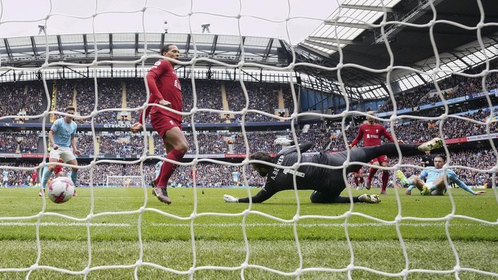 Manchester Citys Jack Grealish, right, scores his his sides fourth goal during the English Premier League soccer match between Manchester City and Liverpool at Etihad stadium in Manchester, England, Saturday, April 1, 2023. (AP Photo/Jon Super)