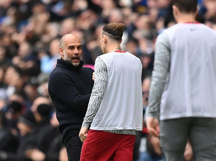 MANCHESTER, ENGLAND - APRIL 01: Manchester City manager Pep Guardiola speaks to Konstantinos Tsimikas of Liverpool after the first Manchester City goal during the Premier League match between Manchester City and Liverpool FC at Etihad Stadium on April 01, 2023 in Manchester, England. (Photo by Michael Regan/Getty Images)