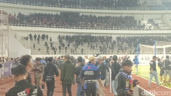 Suasana keributan antar-suporter di tengah laga PSIS Semarang melawan PSS Sleman di Stadion Jatidiri Semarang, Minggu (2/4/2023) malam.