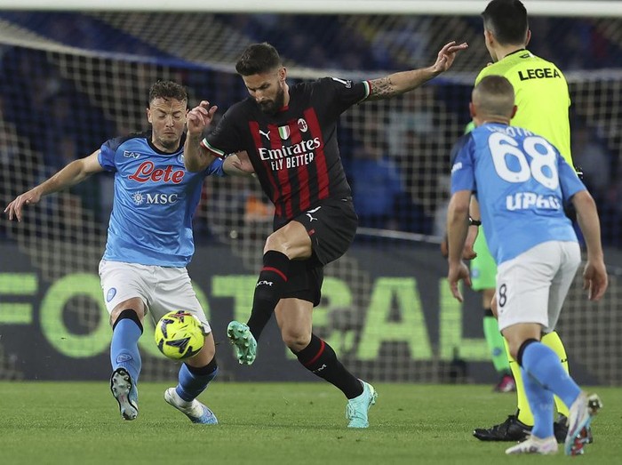 AC Milan's Olivier Giroud is challenged by Napoli's Amir Rrahmani, left,  during the Serie A soccer match between Napoli and AC Milan, in Naples, Italy, Sunday, April 2, 2023. (Alessandro Garofalo/LaPresse via AP)