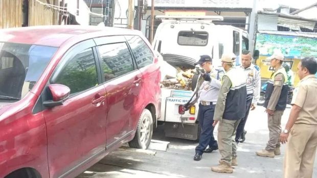 Video warga cekcok karena jalan umum di Jelambar, Jakbar dipakai untuk parkiran viral di medsos. Petugas menderek mobil yang ada di lokasi. (IG @kel.jelambarbaru)