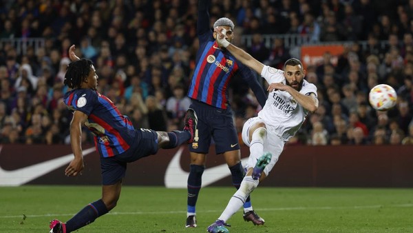 Real Madrids Karim Benzema, right, attempts a shot at goal and misses past Barcelonas Jules Kounde, left, during the Spanish Copa del Rey semifinal, second leg soccer match between Barcelona and Real Madrid at the Camp Nou stadium in Barcelona, Spain, Wednesday, April 5, 2023. (AP Photo/Joan Monfort)