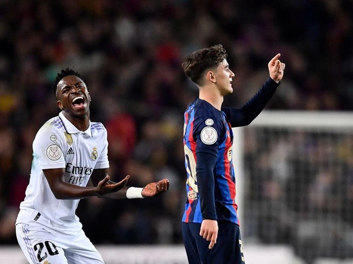 Real Madrid's Brazilian forward Vinicius Junior (L) and Barcelona's Spanish midfielder Gavi gesture during the Copa del Rey (King's Cup) semi-final second leg football match between FC Barcelona and Real Madrid CF at the Camp Nou stadium in Barcelona on April 5, 2023. (Photo by Pau BARRENA / AFP) (Photo by PAU BARRENA/AFP via Getty Images)