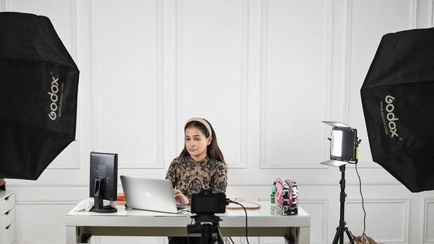 In this photo taken on March 17, 2023, social media influencer and make-up artist Faby does her make-up while going live on her YouTube channel in Mumbai. - Cheap internet data, rising income levels and the world's largest population of young people have fuelled an explosion in India's beauty and personal care market, with social media influencers finding fans across the world with a simple mantra: brown is beautiful. (Photo by SUJIT JAISWAL / AFP) / To go with AFP story 'INDIA-INTERNET-BEAUTY-COSMETICS-INFLUENCERS,FOCUS' by Nivrita GANGULY and Anuradha PRASAD