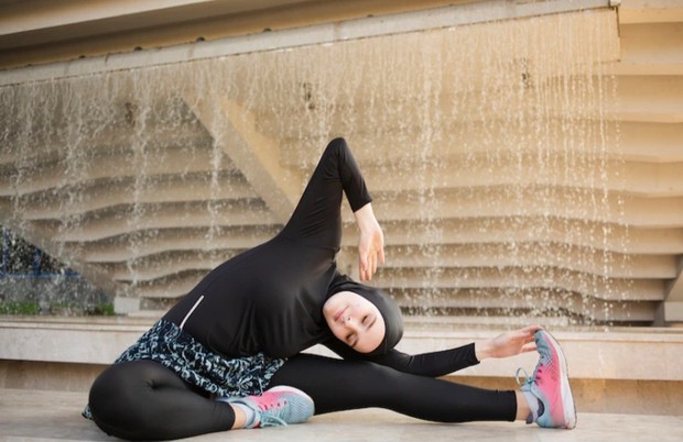 Perempuan muslim sedang berolahraga/Foto: freepik.com Gambar perempuan muslim dengan pakaian olahraga sedang pemanasan.