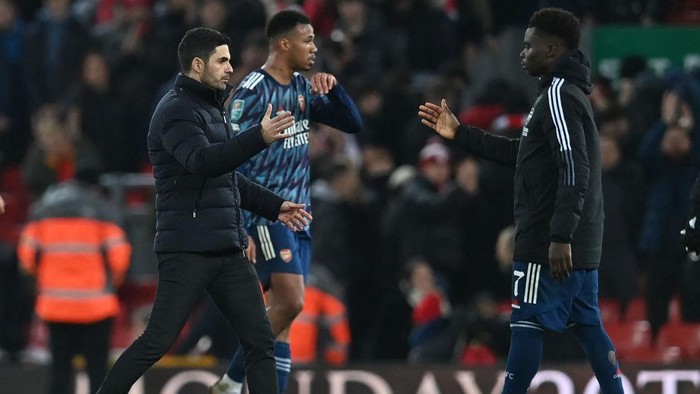 Arsenals Spanish manager Mikel Arteta (L) shakes hands with Arsenals English midfielder Bukayo Saka (R) after the English League Cup semi-final first leg football match between Liverpool and Arsenal at Anfield in Liverpool, north west England on January 13, 2022. - The game finished 0-0. - RESTRICTED TO EDITORIAL USE. No use with unauthorized audio, video, data, fixture lists, club/league logos or live services. Online in-match use limited to 120 images. An additional 40 images may be used in extra time. No video emulation. Social media in-match use limited to 120 images. An additional 40 images may be used in extra time. No use in betting publications, games or single club/league/player publications. (Photo by Paul ELLIS / AFP) / RESTRICTED TO EDITORIAL USE. No use with unauthorized audio, video, data, fixture lists, club/league logos or live services. Online in-match use limited to 120 images. An additional 40 images may be used in extra time. No video emulation. Social media in-match use limited to 120 images. An additional 40 images may be used in extra time. No use in betting publications, games or single club/league/player publications. / RESTRICTED TO EDITORIAL USE. No use with unauthorized audio, video, data, fixture lists, club/league logos or live services. Online in-match use limited to 120 images. An additional 40 images may be used in extra time. No video emulation. Social media in-match use limited to 120 images. An additional 40 images may be used in extra time. No use in betting publications, games or single club/league/player publications. (Photo by PAUL ELLIS/AFP via Getty Images)
