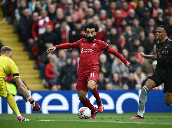 Liverpool's Egyptian striker Mohamed Salah (C) runs to shoot wide of Arsenal's English goalkeeper Aaron Ramsdale during the English Premier League football match between Liverpool and Arsenal at Anfield in Liverpool, north west England on April 9, 2023. (Photo by Paul ELLIS / AFP) / RESTRICTED TO EDITORIAL USE. No use with unauthorized audio, video, data, fixture lists, club/league logos or 'live' services. Online in-match use limited to 120 images. An additional 40 images may be used in extra time. No video emulation. Social media in-match use limited to 120 images. An additional 40 images may be used in extra time. No use in betting publications, games or single club/league/player publications. /  (Photo by PAUL ELLIS/AFP via Getty Images)