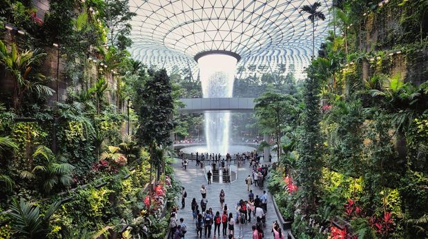 Jewel Changi Airport, Singapore - 5th August, 2019: Visitors tour around the Rain Vortex inside the Jewel area at Changi Airport. It's the world's tallest waterfall at 130 ft in height and surrounded by a four-storey terraced forest. The Jewel complex and waterfall was designed by Moshe Safdie.