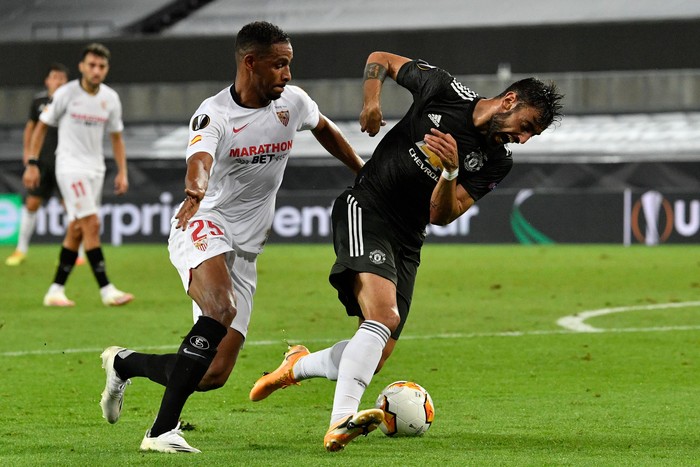 Sevillas Brazilian midfielder Fernando and Manchester Uniteds Portuguese midfielder Bruno Fernandes (R) vie for the ball during the UEFA Europa League semi-final football match Sevilla v Manchester United on August 16, 2020 in Cologne, western Germany. (Photo by Martin Meissner / POOL / AFP) (Photo by MARTIN MEISSNER/POOL/AFP via Getty Images)