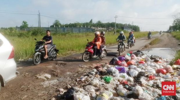 Jalan Raya Terusan Ryacudu yang tidak jauh dari arah pintu tol Kota dijadikan tempat pembuangan sampah sembarangan. Kondisi tumpukkan sampah di badan jalan itu, selain merusak pemandangan juga menimbulkan bau tidak sedap dan terkesan jorok. (CNNIndonesia/Zainal)