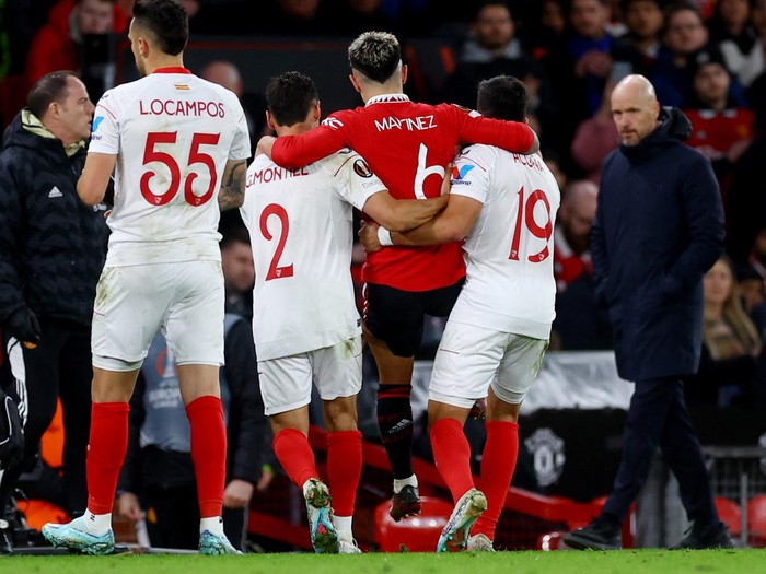 Soccer Football - Europa League - Quarter Final - First Leg - Manchester United v Sevilla - Old Trafford, Manchester, Britain - April 13, 2023  Manchester United's Lisandro Martinez is helped off the pitch by Sevilla's Marcos Acuna and Gonzalo Montiel after sustaining an injury Action Images via Reuters/Lee Smith